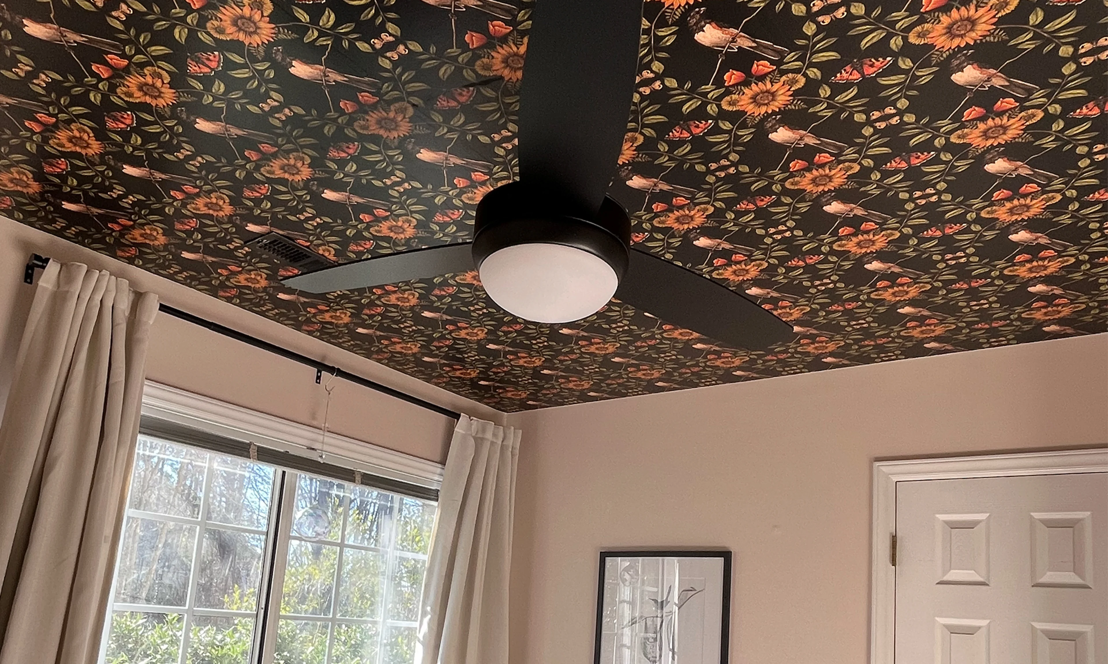 Sunflower and bird wallpaper on the ceiling of a bedroom.