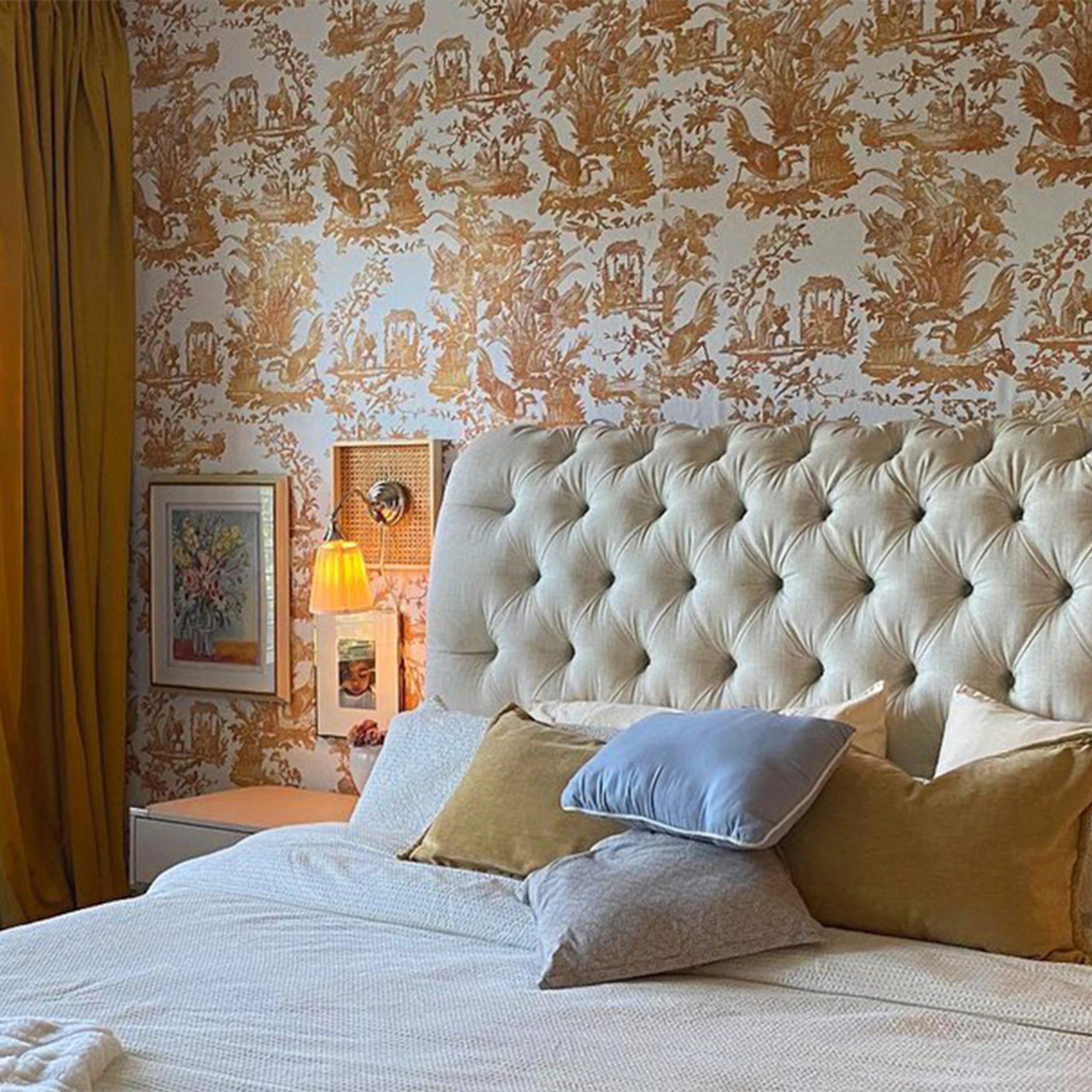 Gold toile wallpaper behind bed.