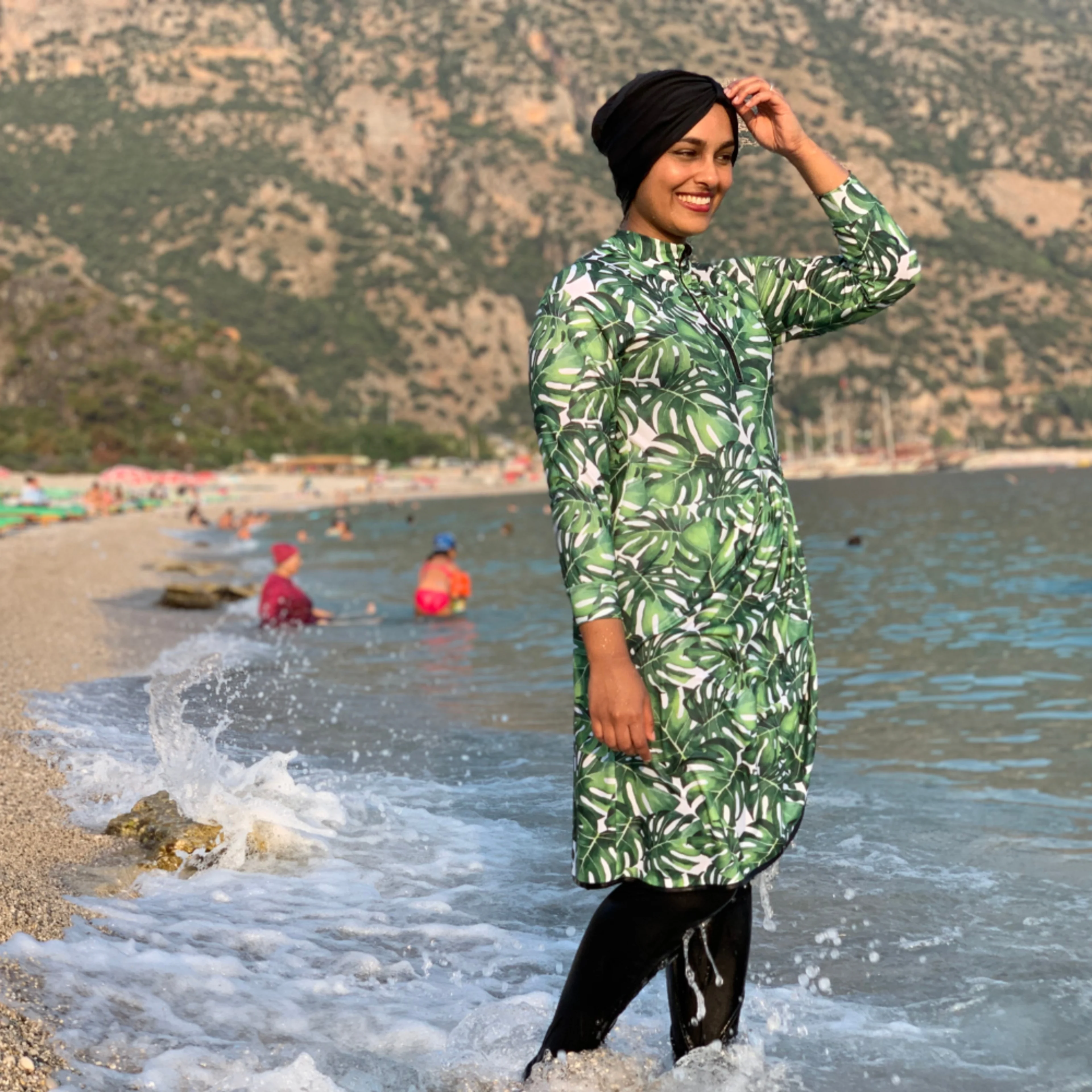 Woman wearing modest swimsuit in monstera print sport lycra